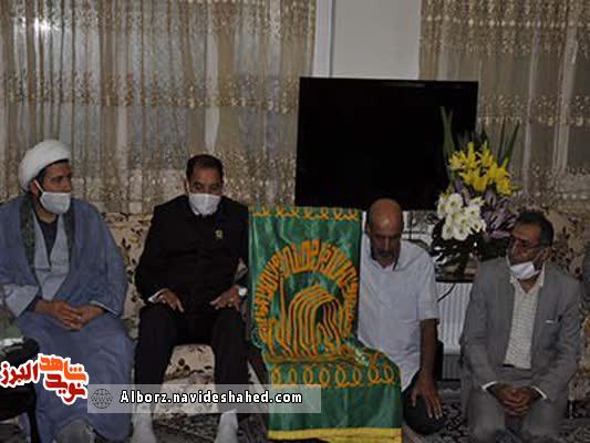 اهداء  پرچم مقدس آستان رضوی به خانواده شهید ملک‌زاده